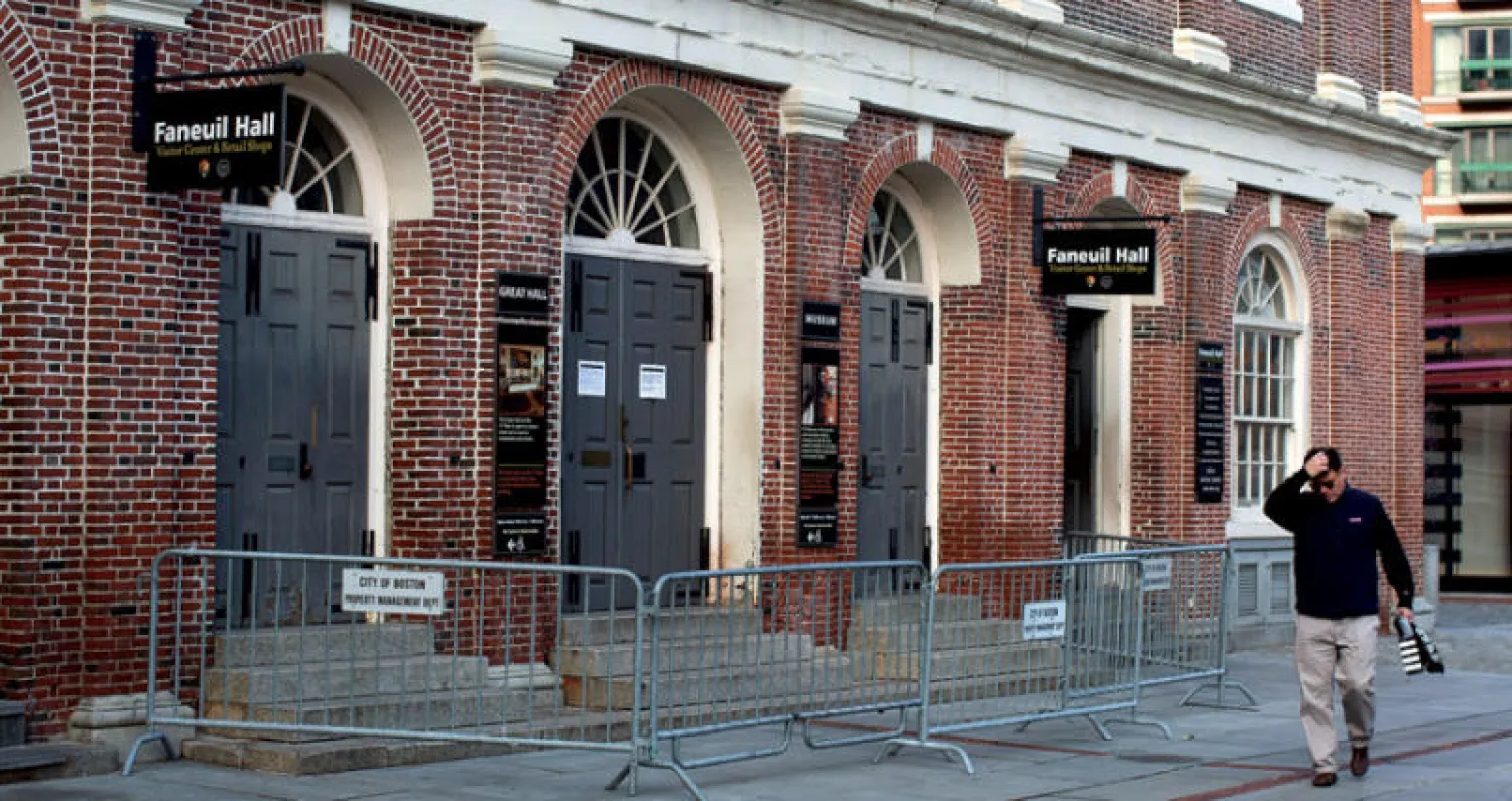 أميركي يمر بالقرب من مبنى حكومي في بوسطن تعرض للإغلاق عقب القرار (إ.ب.أ)