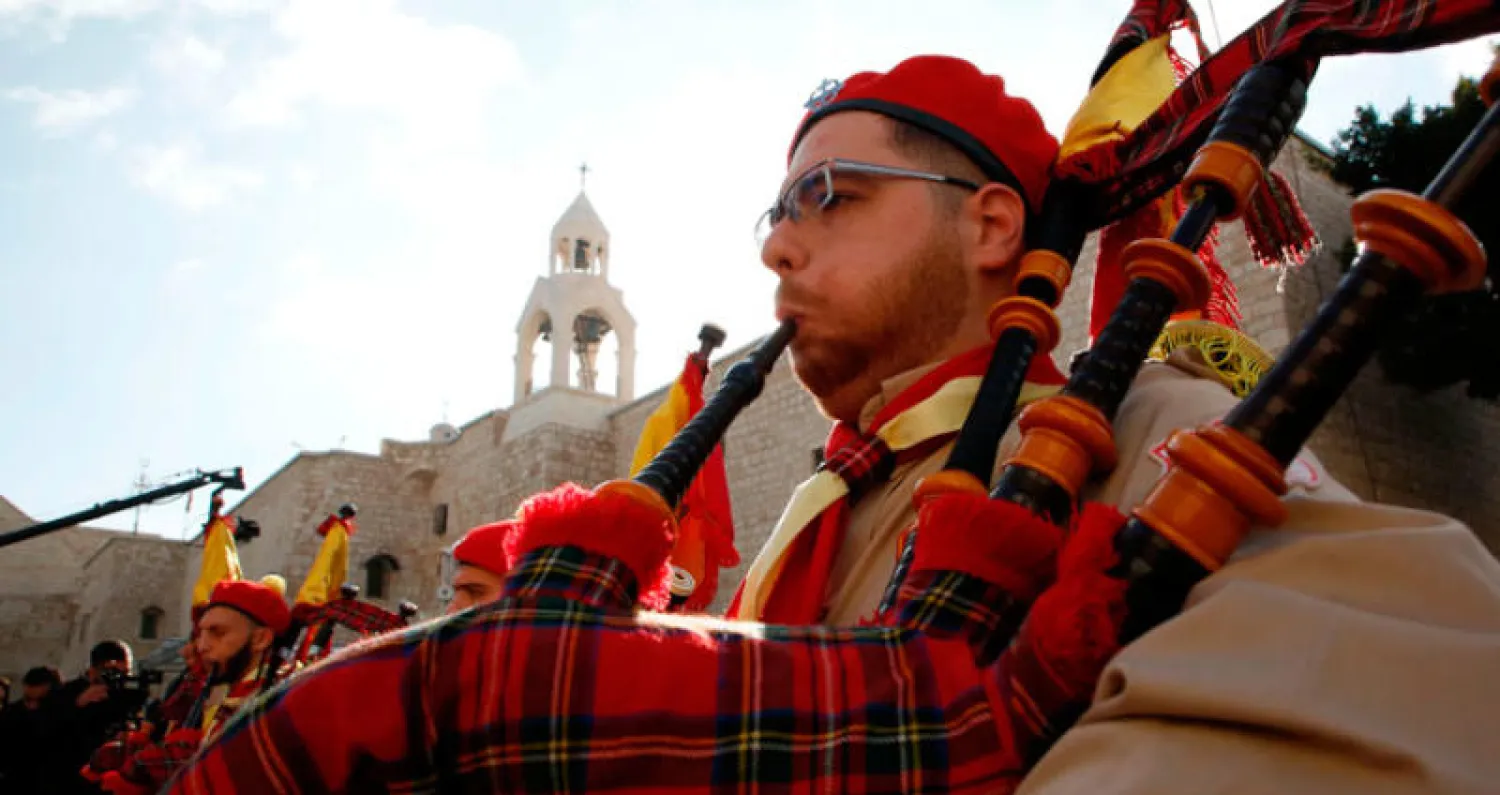 فرقة موسيقية في ساحة المهد أمام كنيسة المهد في بيت لحم بالضفة الغربية أمس (أ.ف.ب)