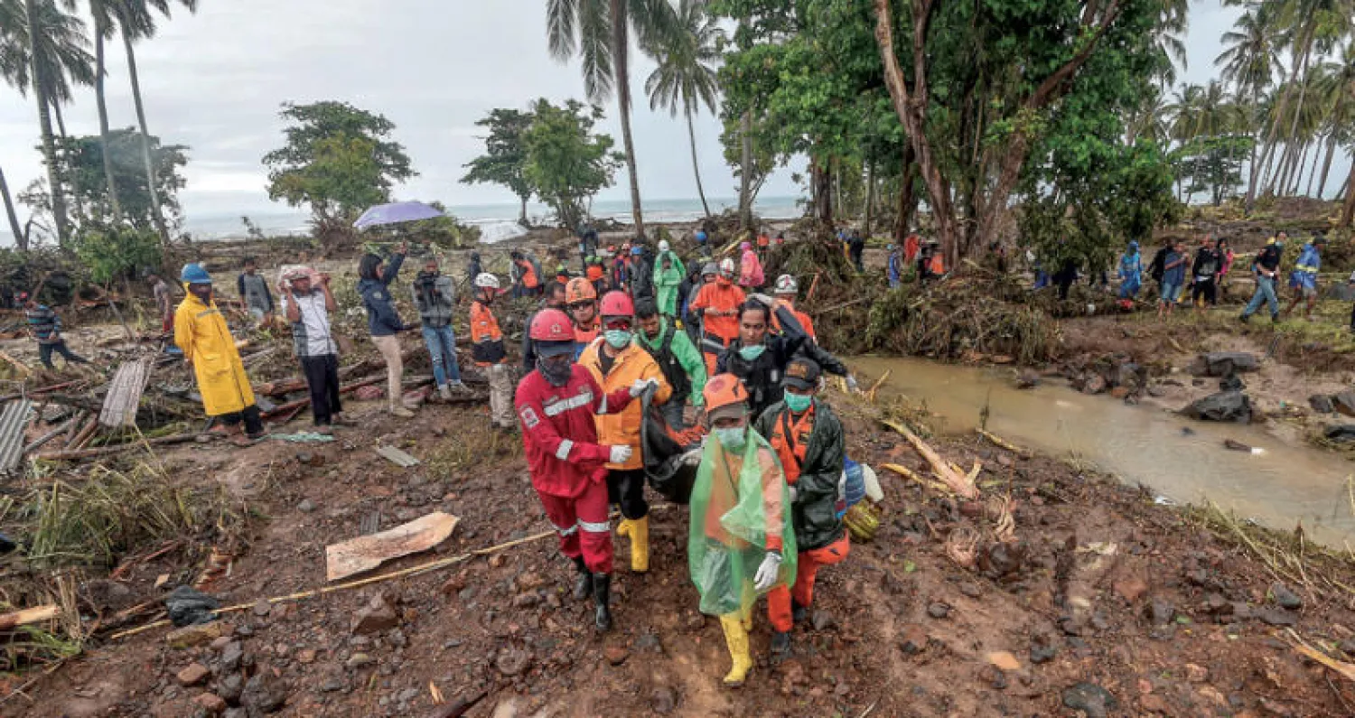رجال الإنقاذ ينقلون رفات أحد ضحايا التسونامي في منطقة بانتن أمس (رويترز)
