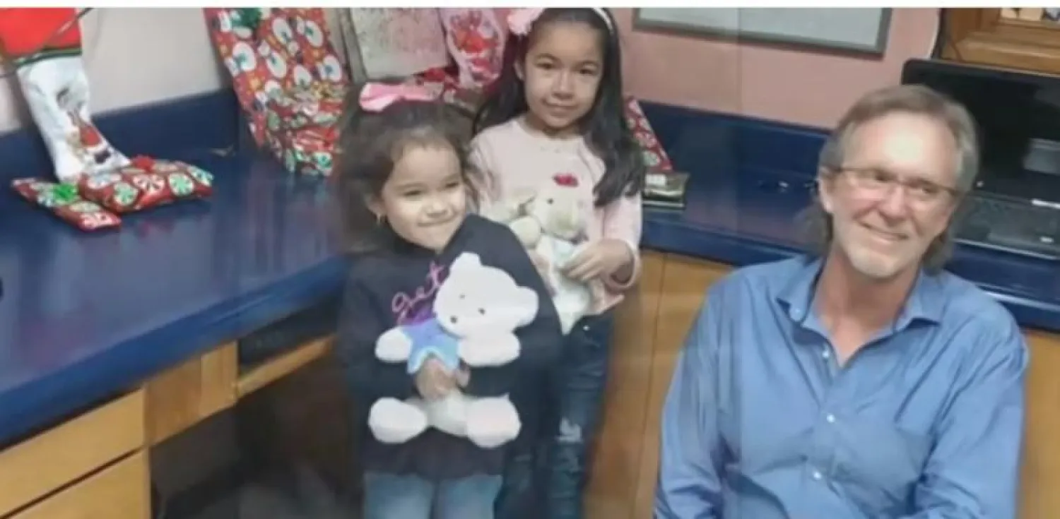 راندي هيس مع الطفلتين بعد أن أحضر لهما الهدايا (تويتر)