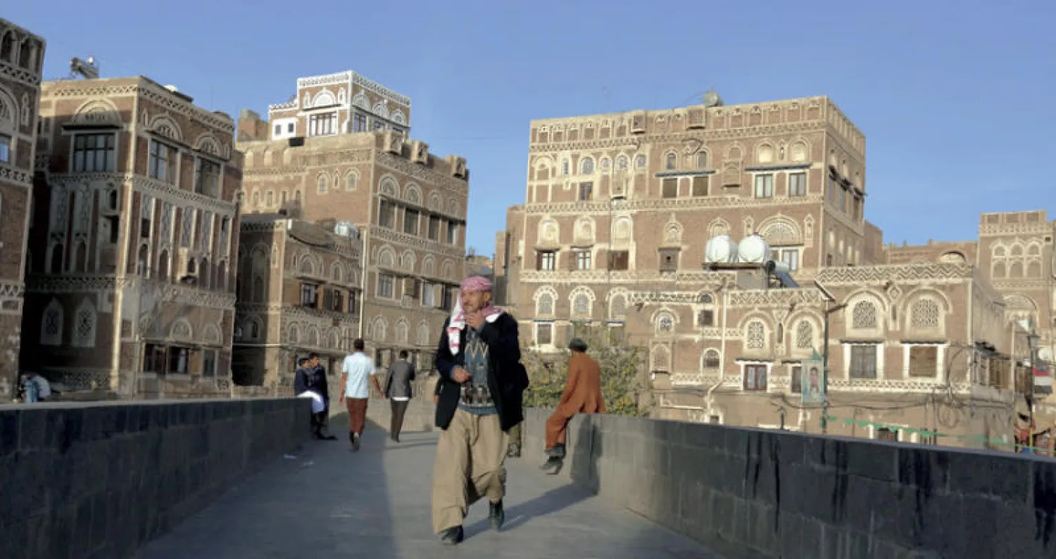 يمنيون في أحد الشوارع المطلة على المدينة القديمة في صنعاء (إ.ب.أ)