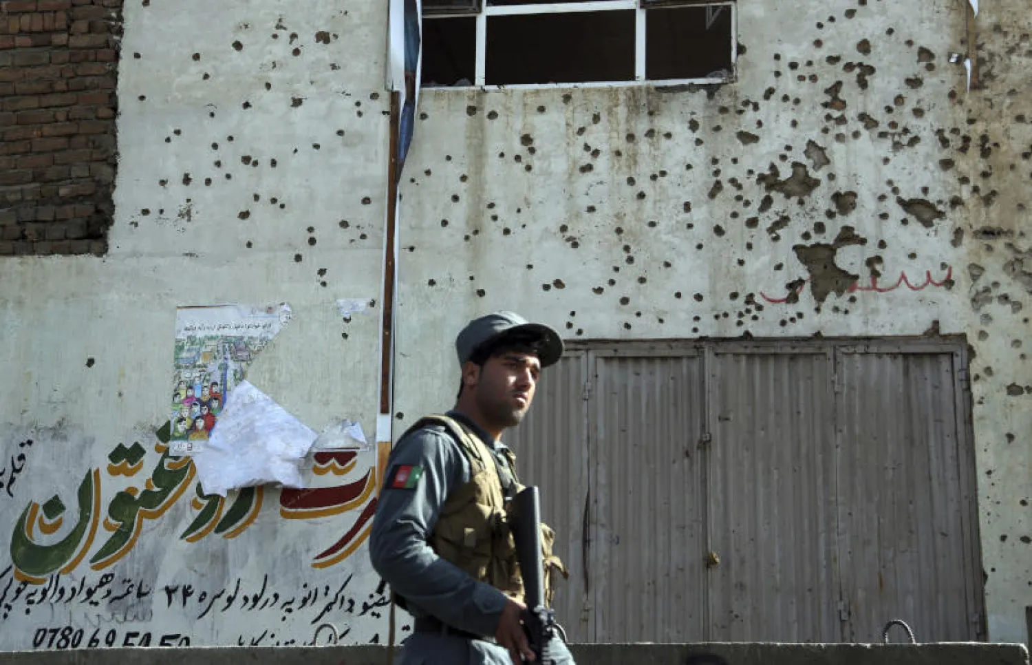 عنصر أمن أفغاني قرب موقع هجوم انتحاري استهدف مكتباً للجنة الانتخابات في كابل (أ.ب)