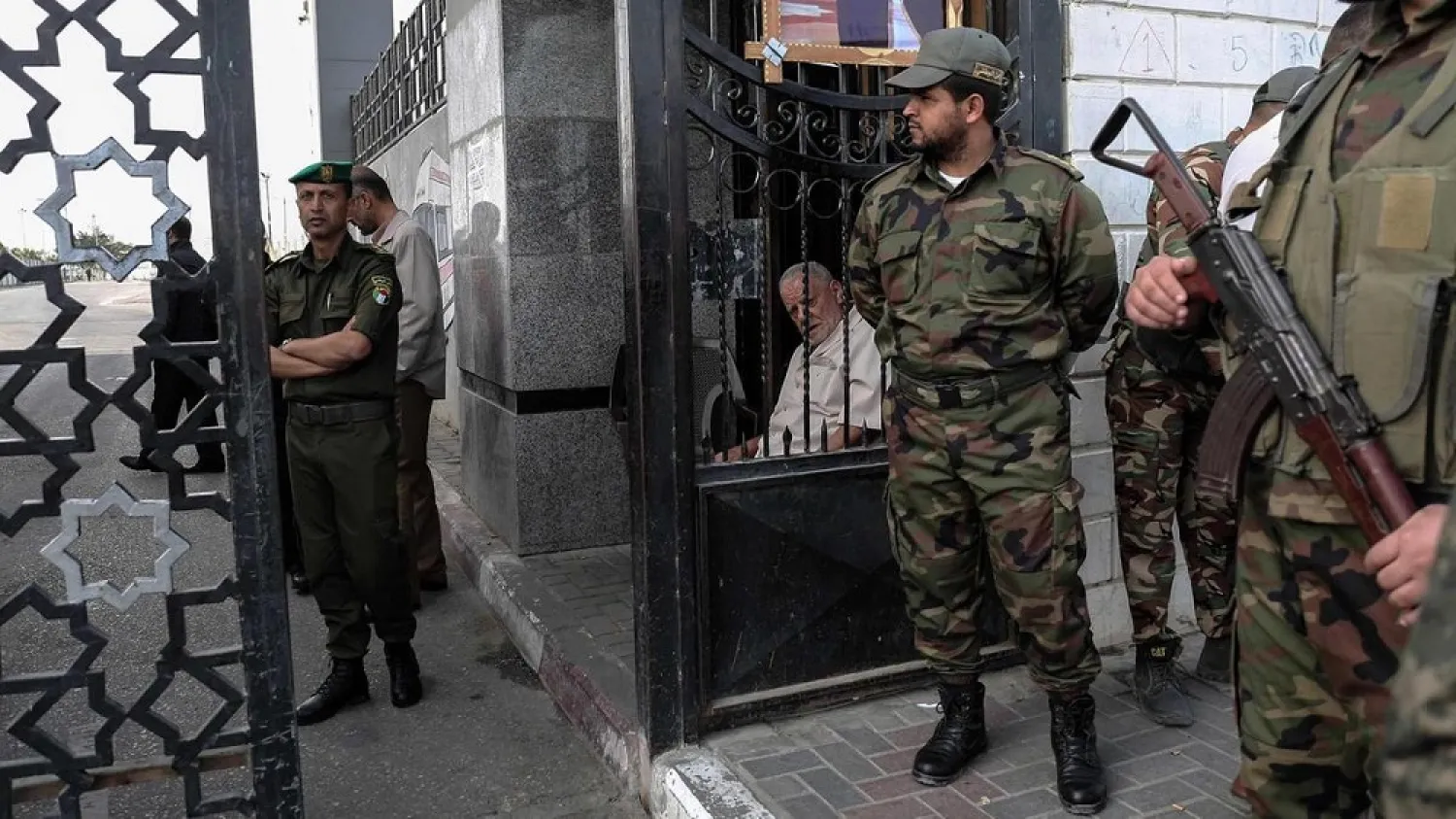 Palestinian security forces loyal to Hamas (right) stand guard outside the Rafah border crossing, as security forces loyal to the Palestinian Authority stand guard inside (left). (AFP)