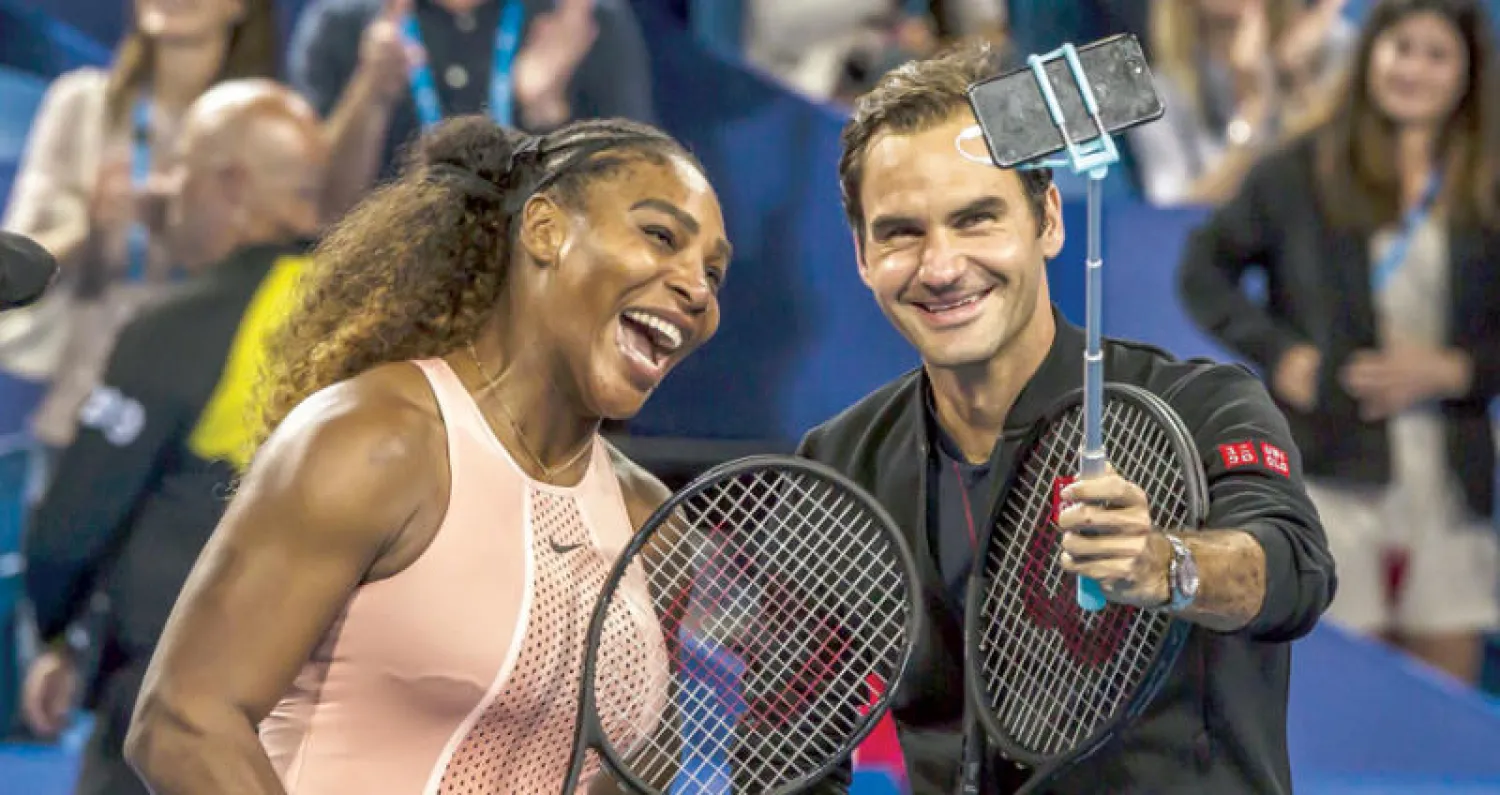 فيدرر يلتقط صورة «سيلفي» مع سيرينا بعد انتهاء مواجهتهما في مباراة الزوجي المختلط بكأس هوبمان (أ.ف.ب)