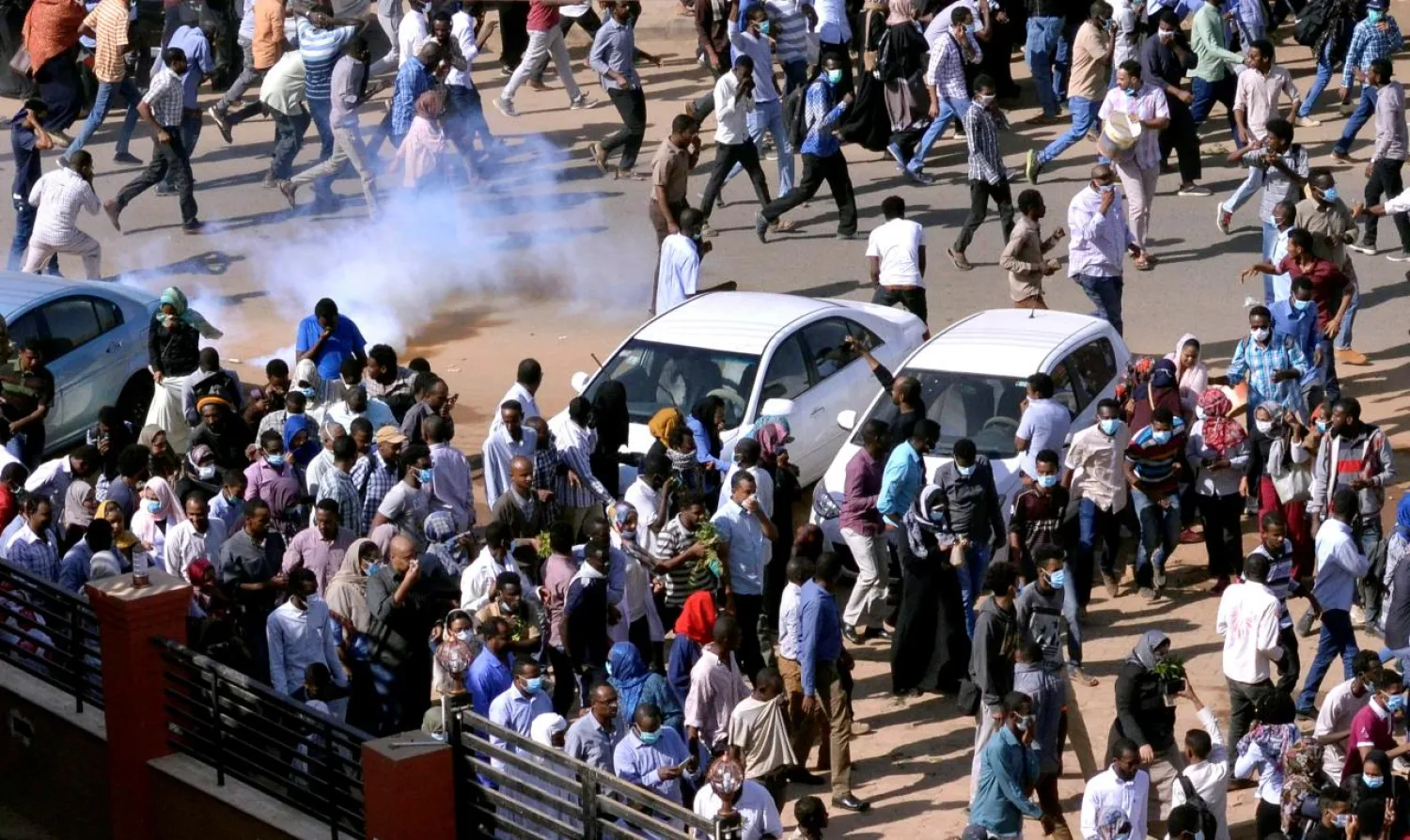 Sudanese demonstrators run from teargas lobbed to disperse them as they march along the street during anti-government protests in Khartoum, Sudan December 25, 2018. (Reuters)