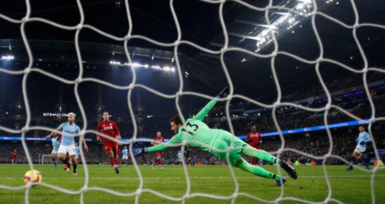 ساني نجم سيتي (يمين) يسجل في مرمى أليسون حارس ليفربول الهدف الذي حسم انتصار فريقه (رويترز)