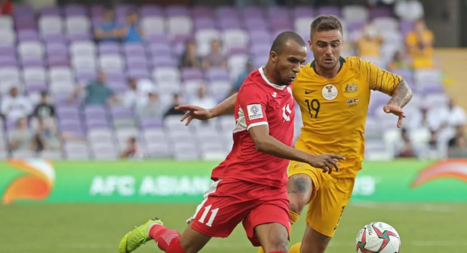 المدافع الأسترالي جوشوا ريسدون يشترك في اللعب مع اللاعب الأردني ياسين بخيت (أ.ف.ب)