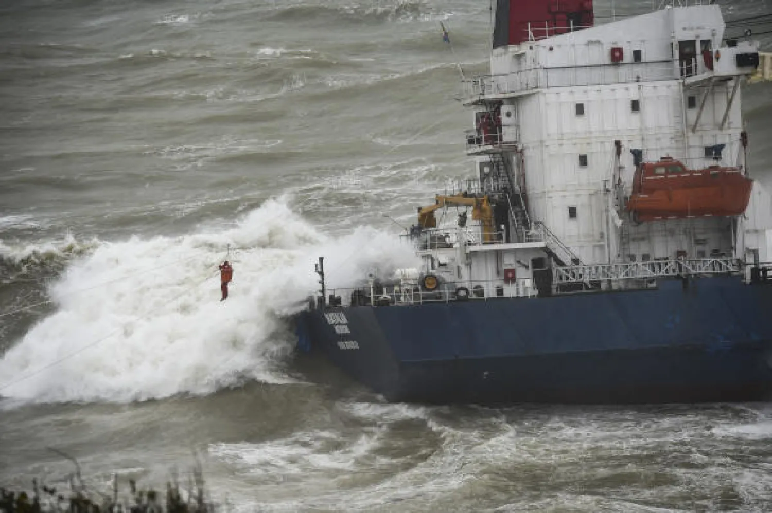 A crew member of a cargo ship that ran aground off the Black Sea coast of Sile, Turkey, is rescued with the help of a winch system extended from the shore, Wednesday, Dec. 19, 2018 AP
