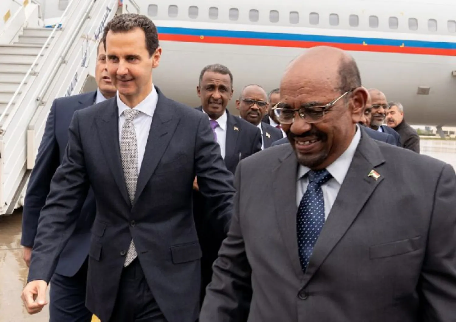  A handout picture released by the Syrian Arab News Agency (SANA) on December 16, 2018 shows Syrian Regime President Bashar al-Assad (L) receiving his Sudanese counterpart Omar al-Bashir upon his arrival at the airport in the Syrian capital Damascus (AFP Photo/STRINGER)