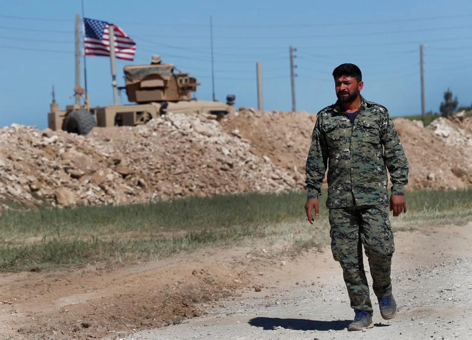 In this April 4, 2018, file photo, a Manbij Military Council member passes a US position near the front line with Turkish-backed fighters, in Manbij, Syria. (AP)