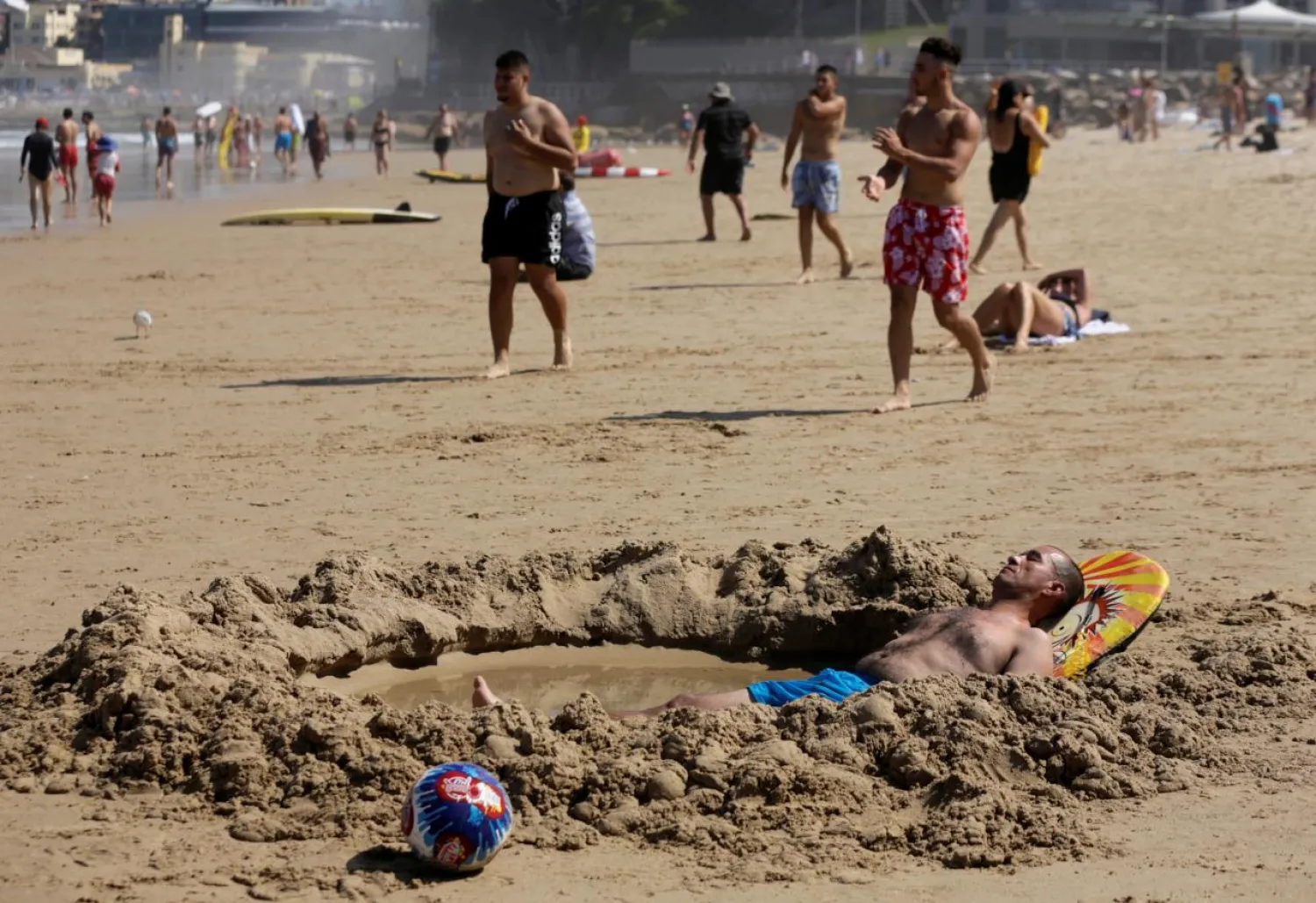 A man lays in a pool of sea water he dug into Sydney's North Cronulla Beach. Reuters file photo