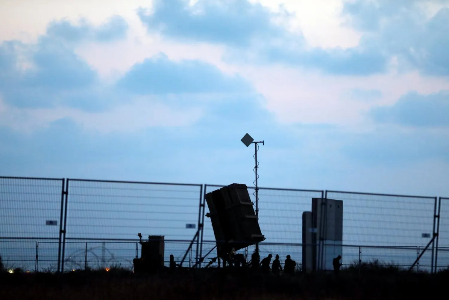 Israeli soldiers walk next to an Iron Dome anti-missile system positioned near the city of Ashkelon, Israel May 29, 2018 REUTERS/ Ronen Zvulun