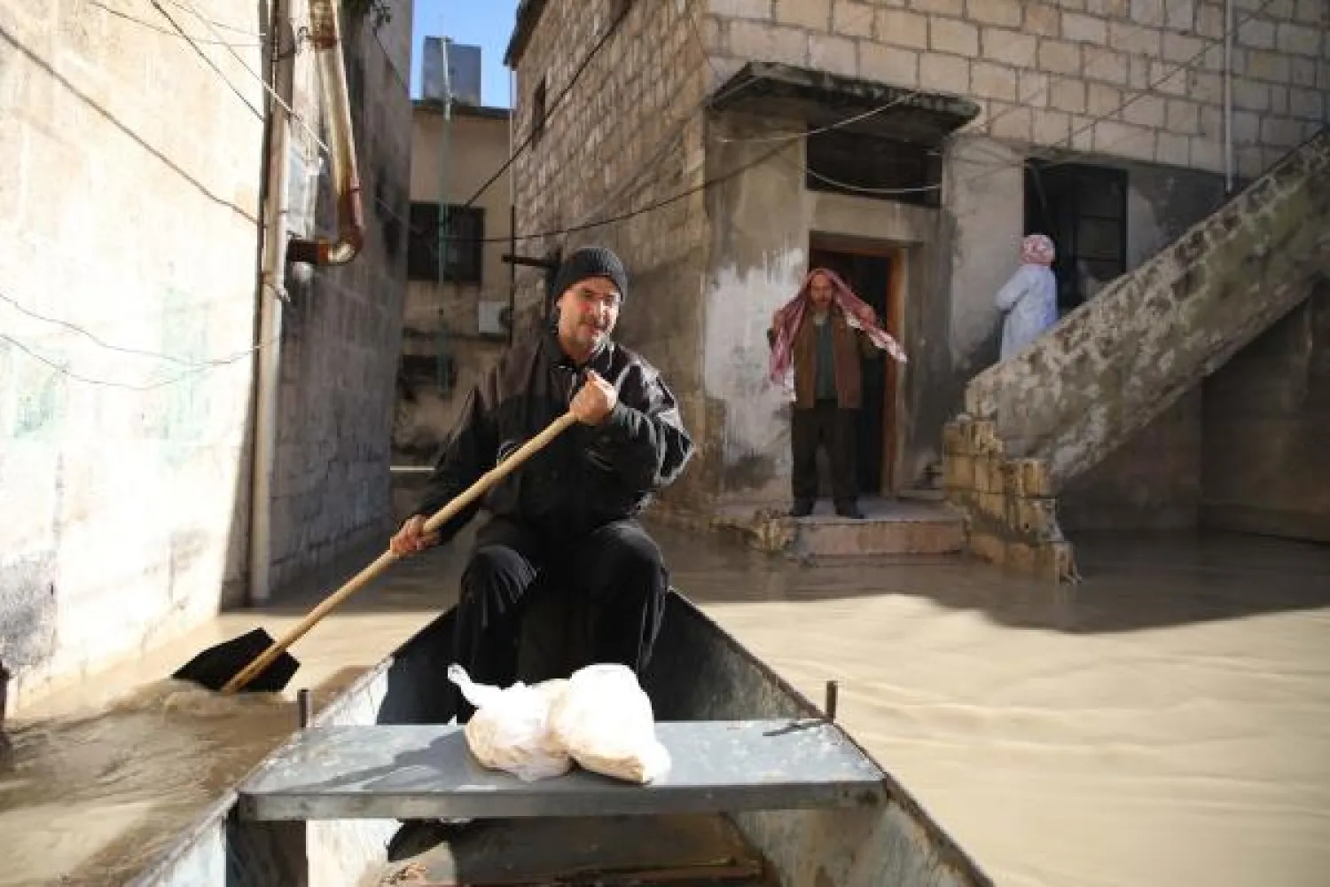 Bags of freshly baked pitta -- Abu Ihab provides free delivery to flood-stricken households unable to reach the shops | AFP