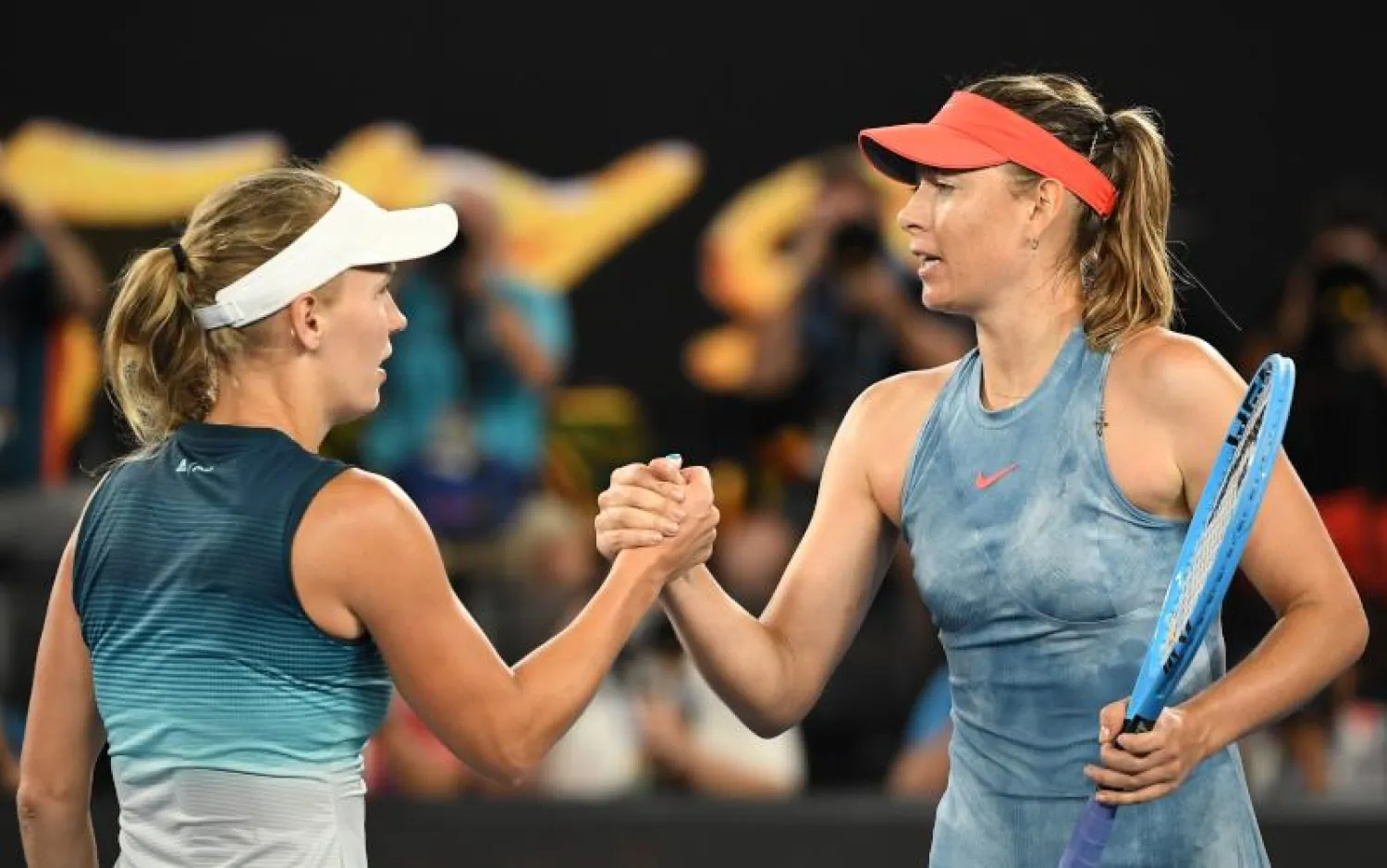 ماريا شارابوفا (يمين) تصافح كارولين ففوزنياكي في نهاية المباراة (أ.ف.ب)