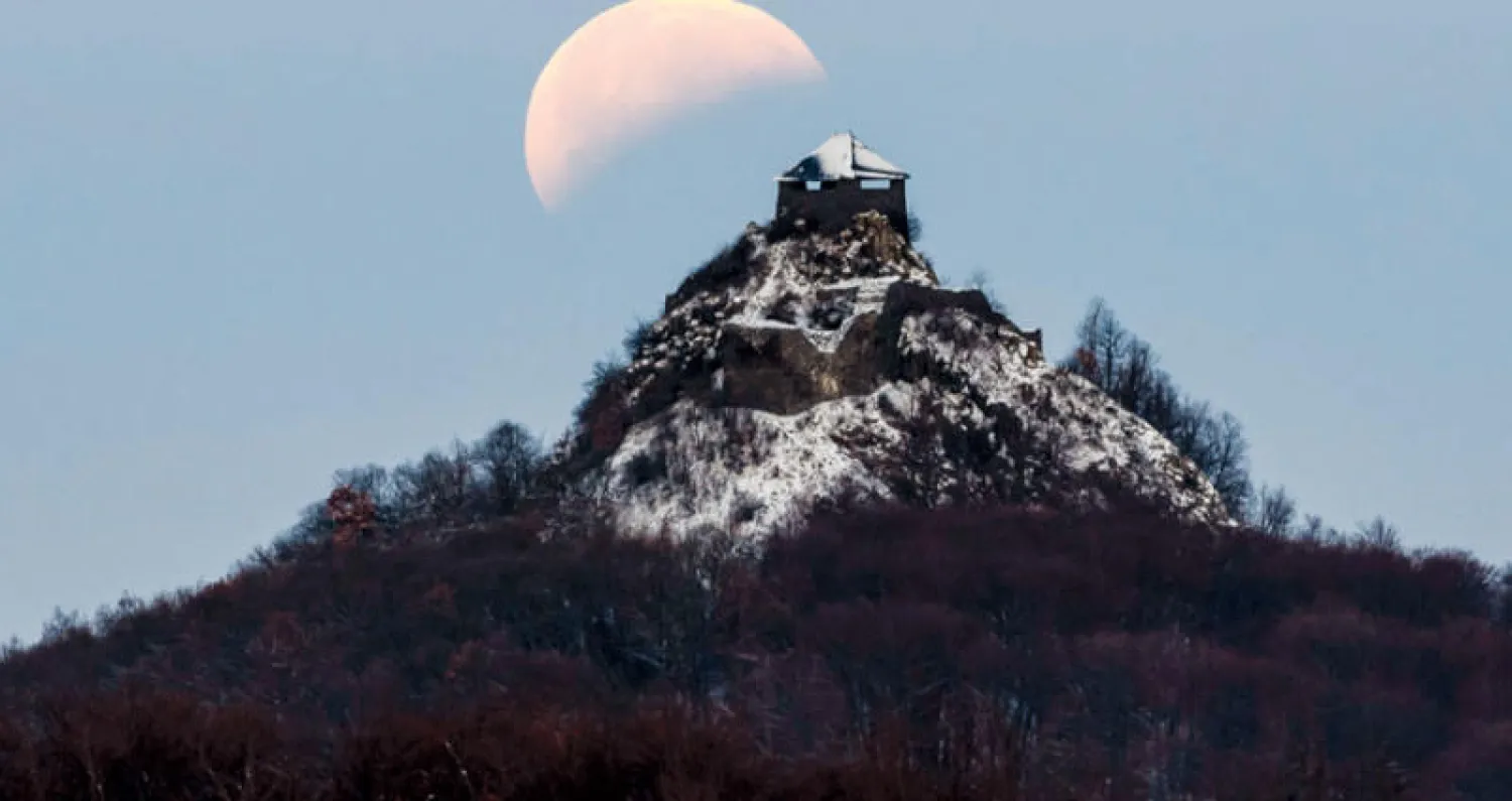 كسوف القمر الكلي فوق قلعة شمال شرقي بودابست (إ.ب.أ)