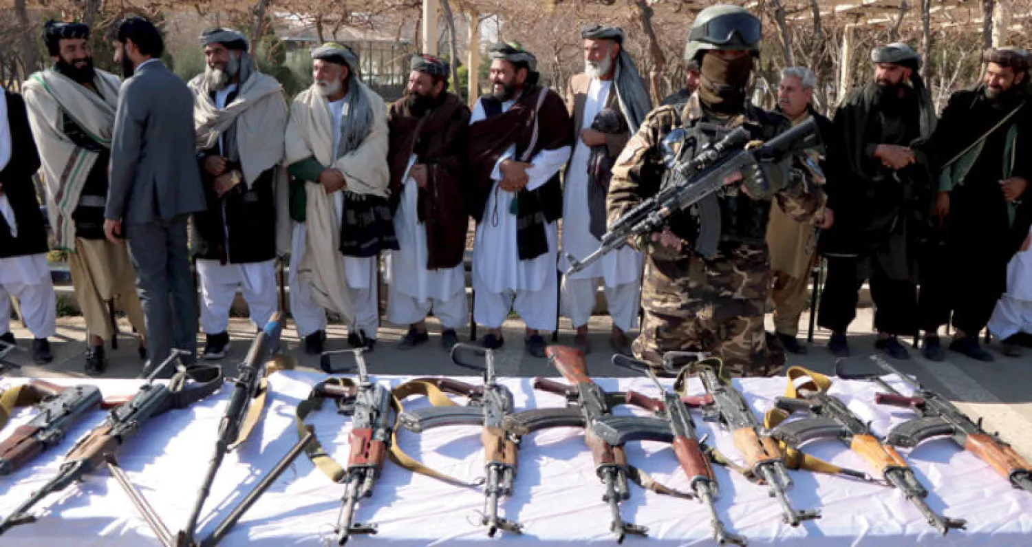 متمردون سابقون يسلّمون أسلحتهم في إطار اتفاق مصالحة مع الحكومة في هيرات بغرب أفغانستان أمس (إ.ب.أ)