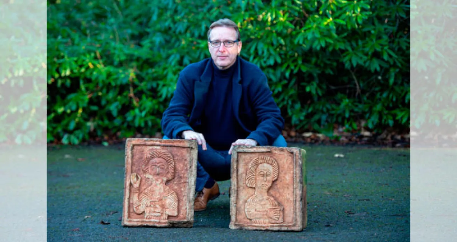 المخبر الفني مع قطعتين عثر عليهما بعد سنوات من سرقتهما من كنيسة إسبانية (أ.ف.ب)