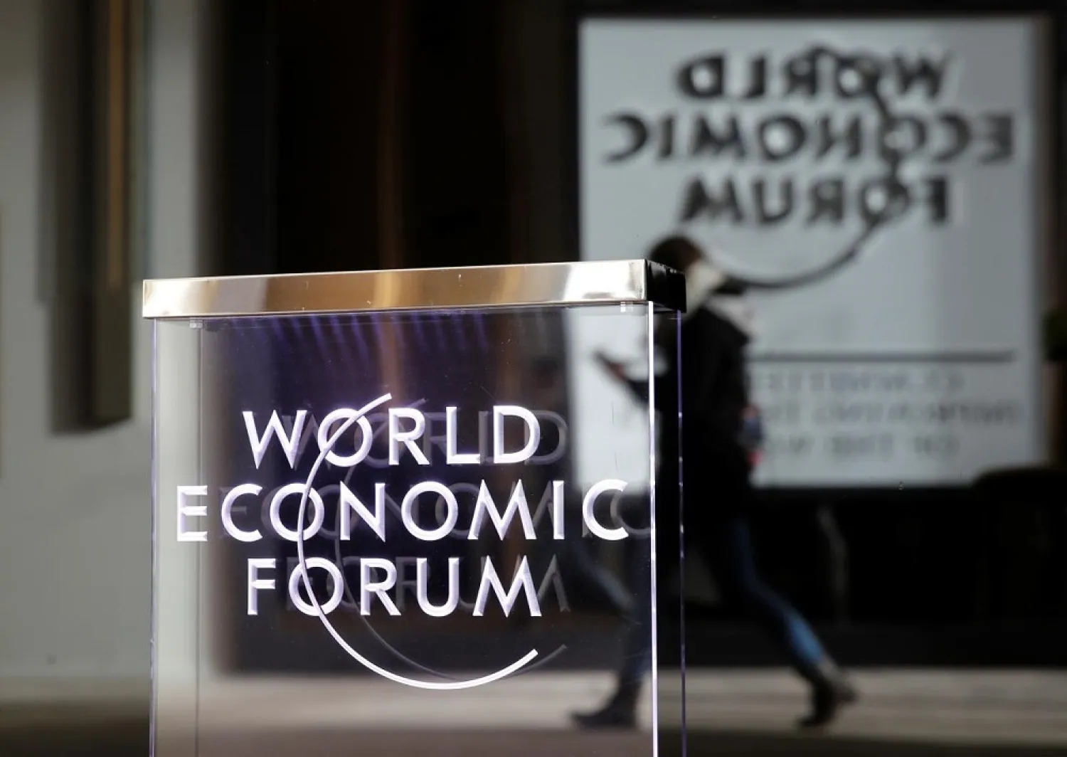 A person passes by a World Economic Forum logo in Davos, Switzerland, January 20, 2019. (Reuters)
