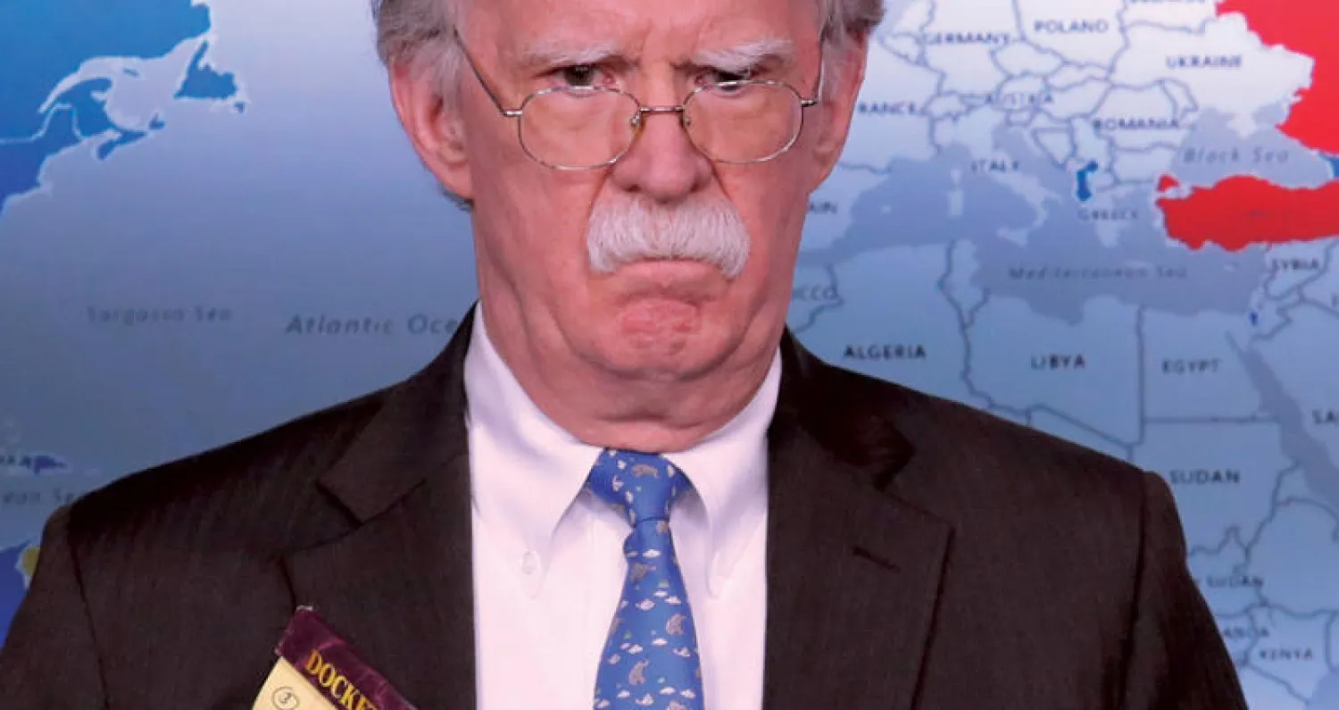 جون بولتون حاملا دفتر ملاحظات تبدو عليه عبارة «5 آلاف جندي إلى كولومبيا} خلال مؤتمر صحافي في البيت الأبيض (رويترز)