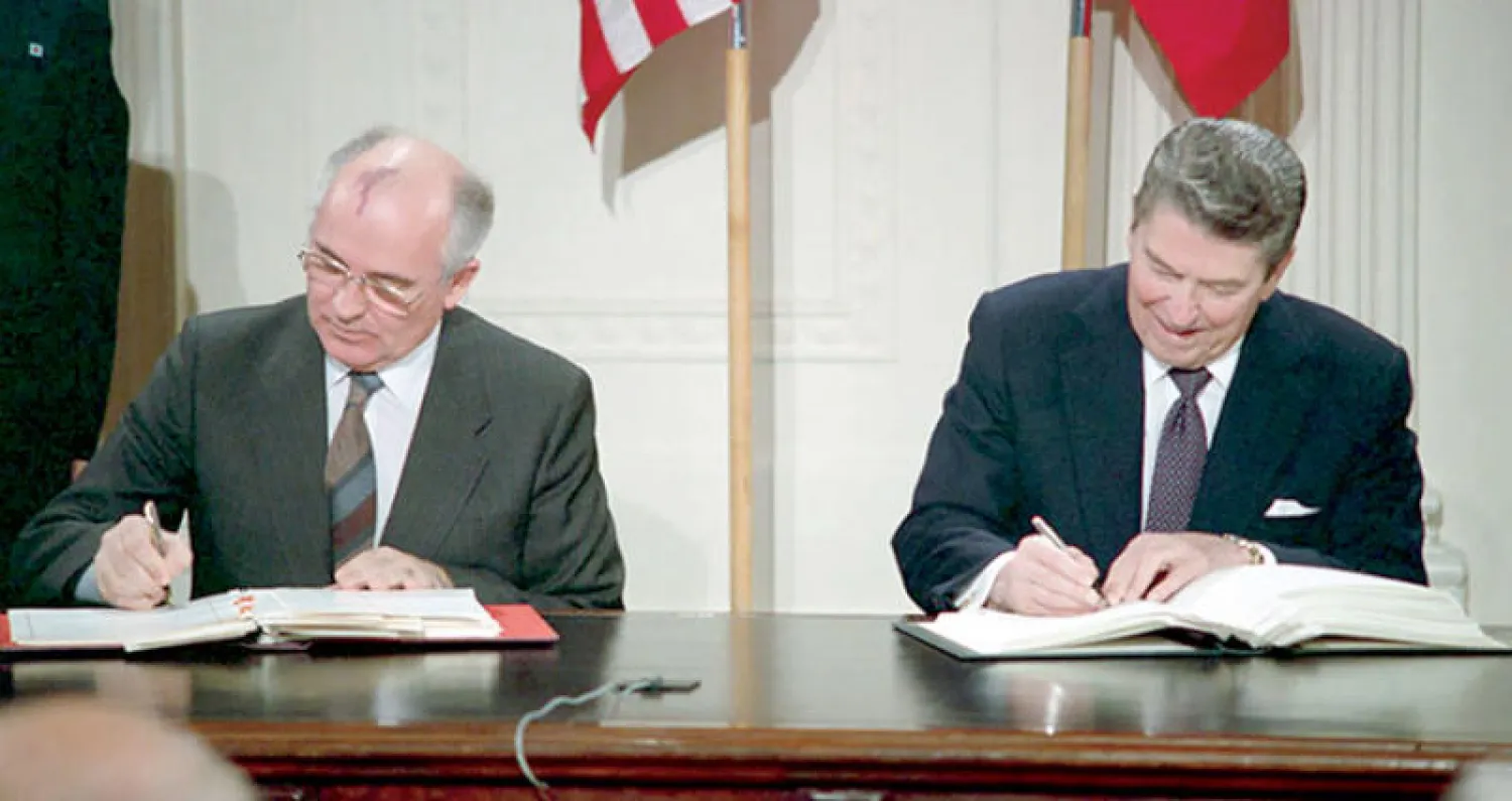 الرئيس الأميركي الراحل رونالد ريغان مع نظيره السوفياتي ميخائيل غورباتشوف يوقعان المعاهدة في البيت الأبيض في ديسمبر 1987 (إ.ب.أ)