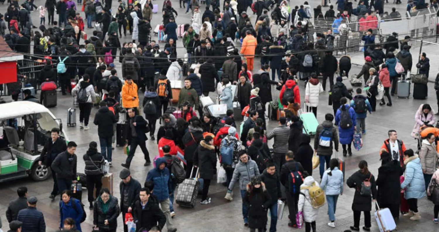 مسافرون خارج محطة سكك حديد العاصمة الصينية بكين يستعدون للسفر لزيارة أسرهم بمناسبة السنة القمرية الجديدة (أ.ف.ب)
