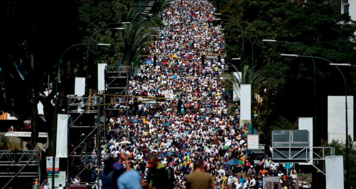 معارضون فنزويليون يشاركون في مظاهرة ضد مادورو في كراكاس أول من أمس (أ.ف.ب)