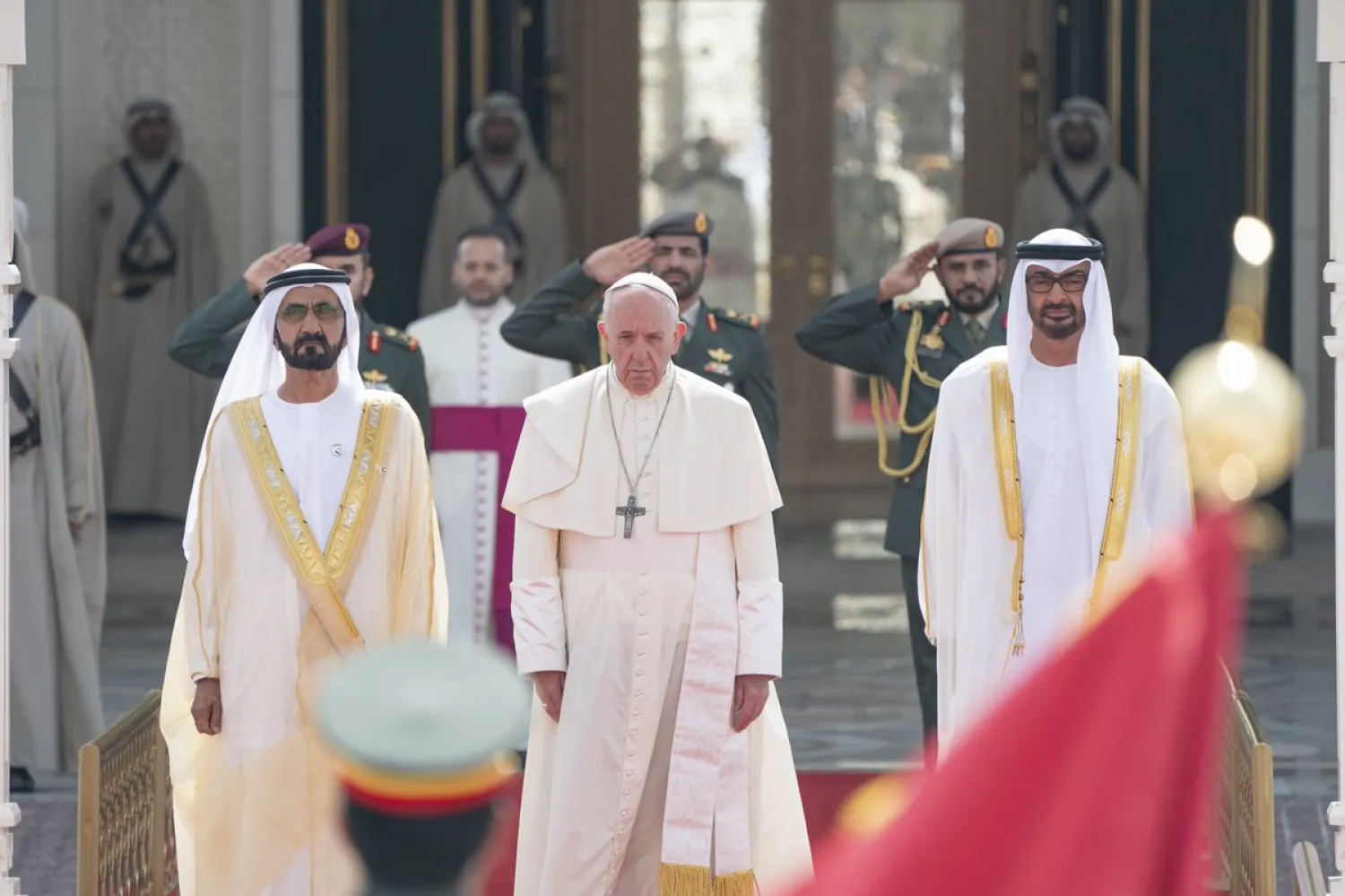 Pope Francis stands next to the Ruler of Dubai and Abu Dhabi's Crown Prince during a welcome ceremony at the Presidential Palace in Abu Dhabi, United Arab Emirates, February 4, 2019. WAM