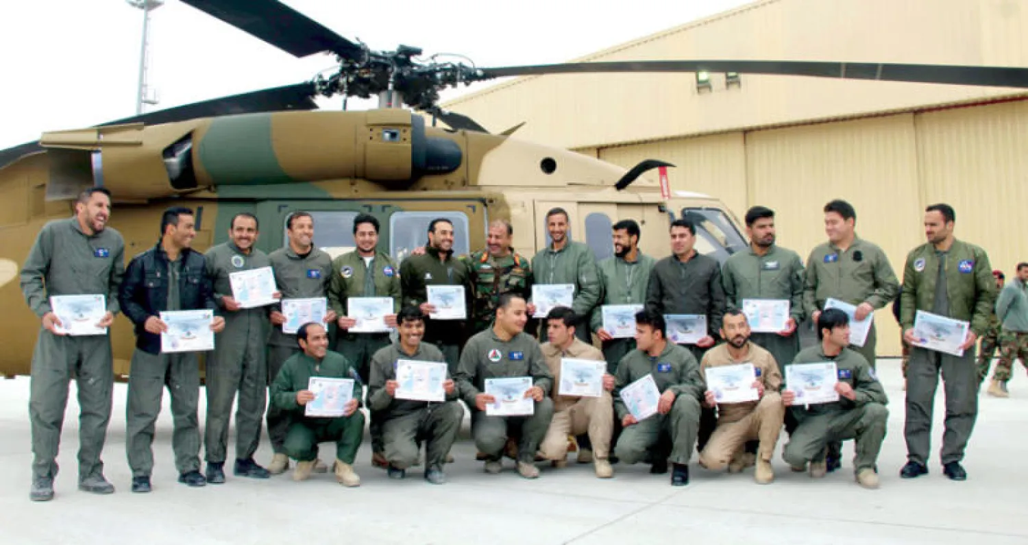 طيارون من القوات الجوية الأفغانية يحضرون حفل تخرج في قندهار أمس بعد ساعات طويلة من التدريب على الطيران بطائرات الهليكوبتر {بلاك هوك} للعمليات القتالية (إ.ب.أ)