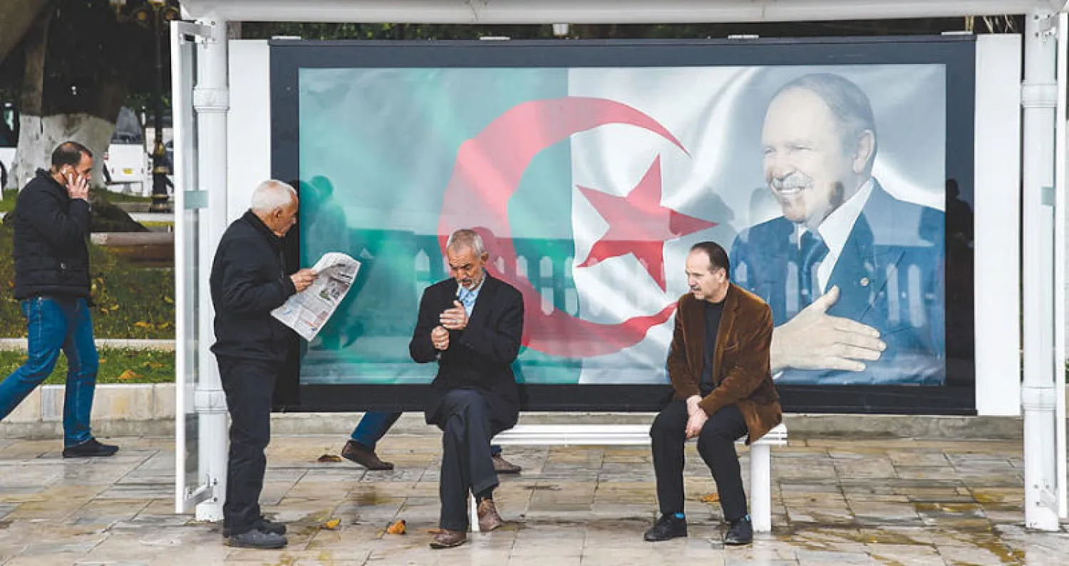 ملصق للرئيس عبد العزيز بوتفليقة عند موقف للحافلات في العاصمة الجزائرية أمس  (أ.ف.ب)