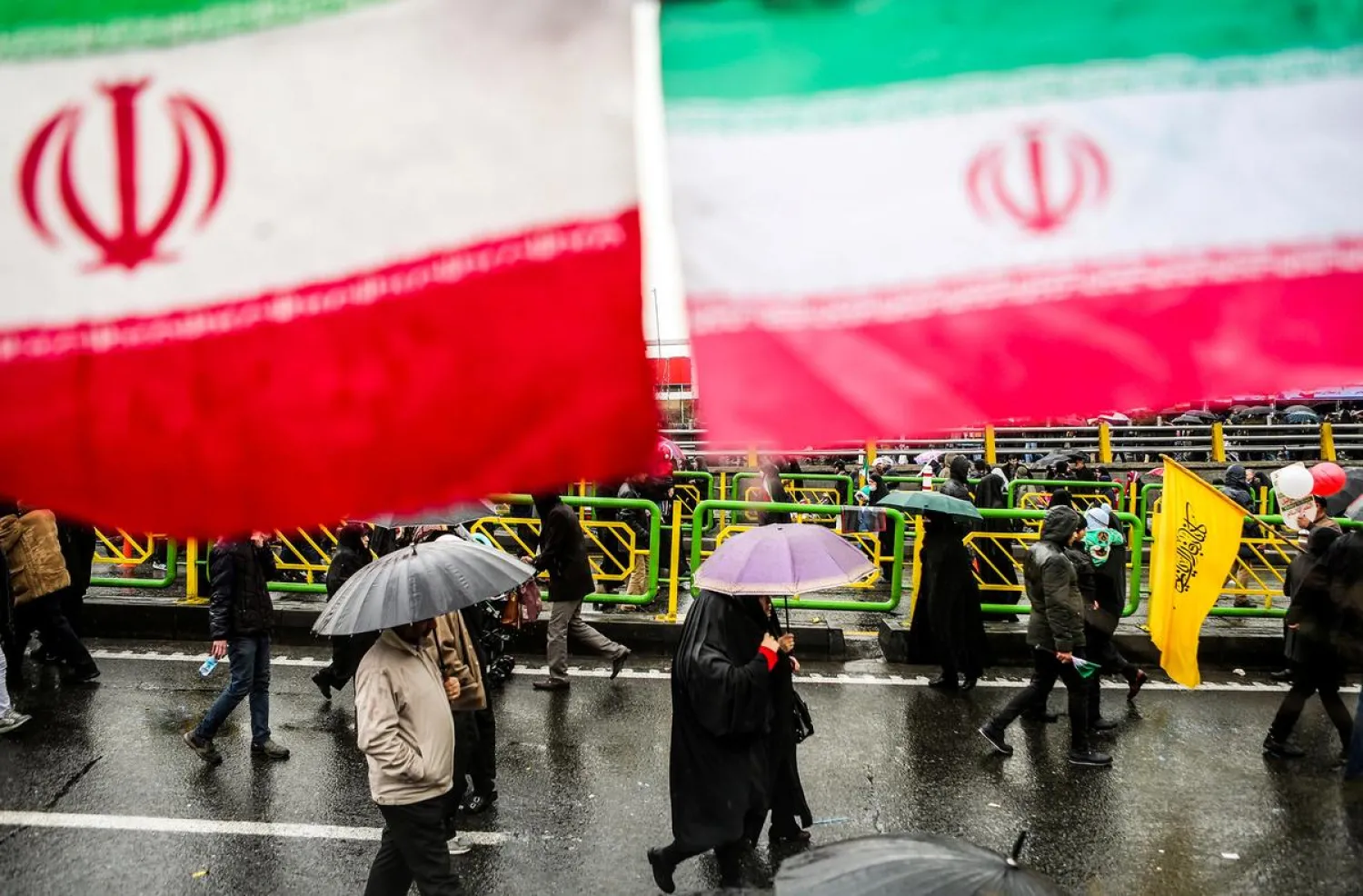 Iranian people carry umbrellas during a ceremony to mark the 40th anniversary of the revolution in Tehran, Iran February 11, 2019. (Reuters)