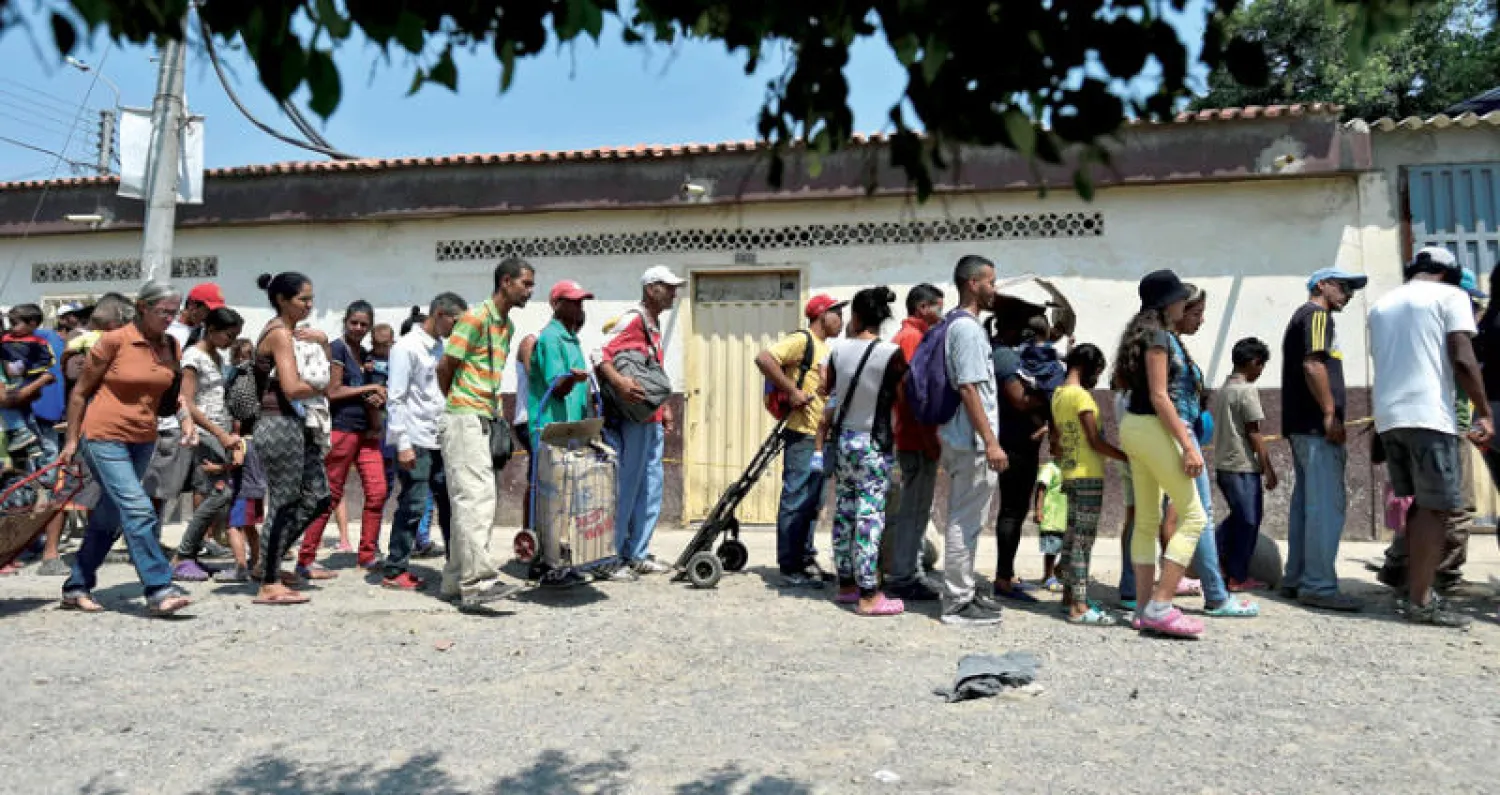 مهاجرون ينتظرون الحصول على بعض المعونات في كولومبيا قريباً من الحدود الفنزويلية (أ.ف.ب)