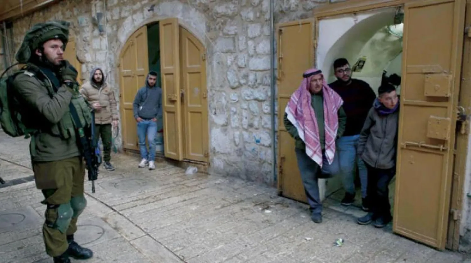 An Israeli soldier guards settlers in Hebron city on Saturday, February 16, 2019. (AFP)