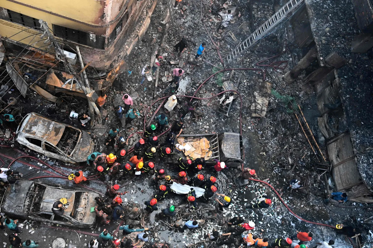 رجال إطفاء يحاولون السيطرة على الحريق الذي اندلع في منطقة قديمة بالعاصمة دكا (ا.ب)