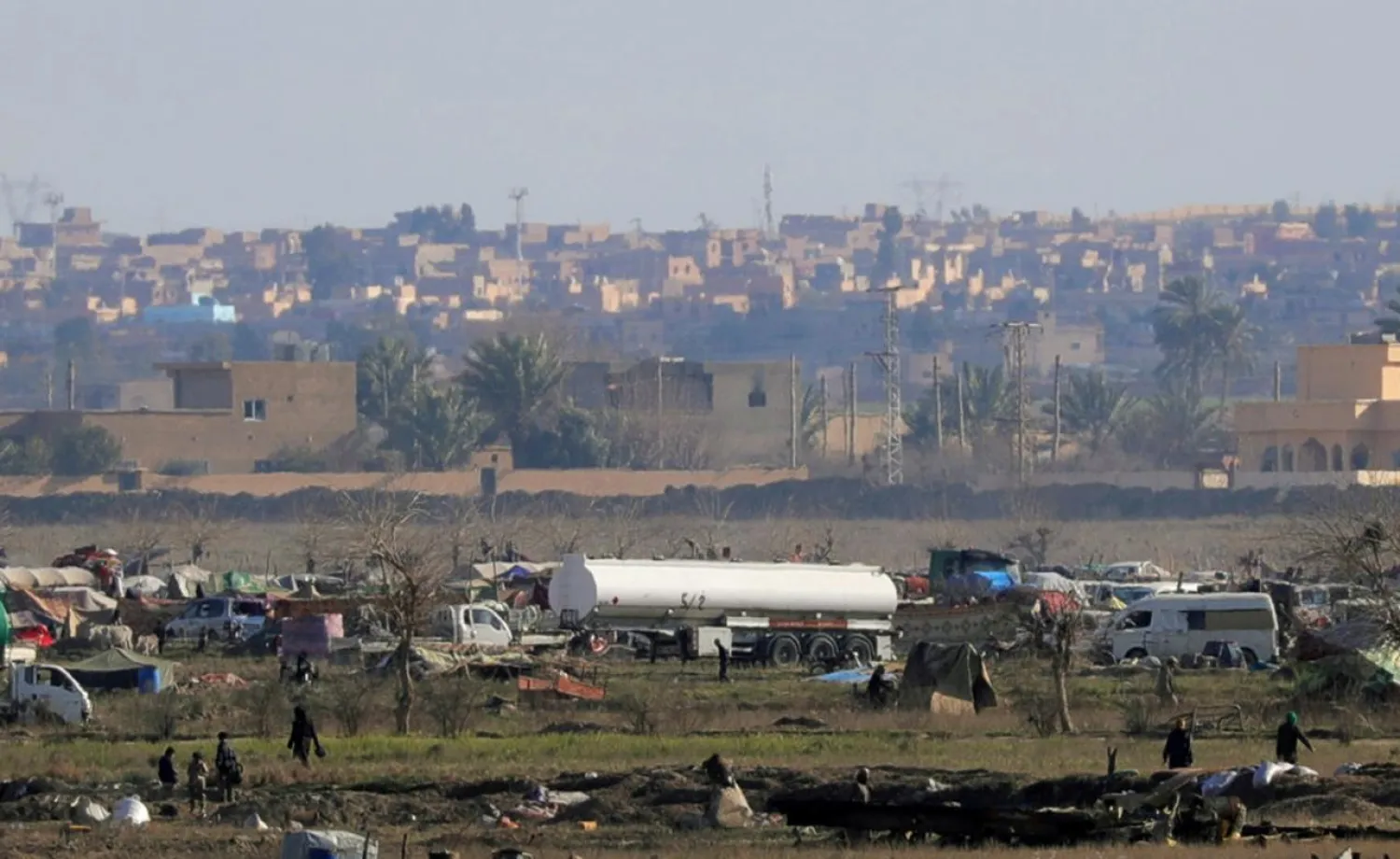 ISIS members walk in the last besieged neighborhood in the village of Baghouz, Deir Ezzor province, Syria February 18, 2019. REUTERS/Rodi Said/File Photo