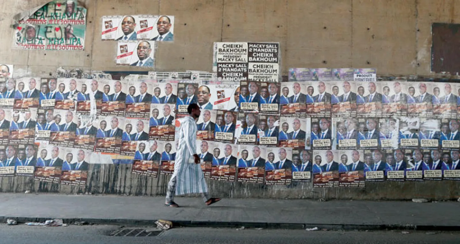ملصقات الدعاية الانتخابية للرئيس ماكي سال في شوارع العاصمة داكار قبل يوم من التوجه إلى صناديق الاقتراع (إ.ب.أ)
