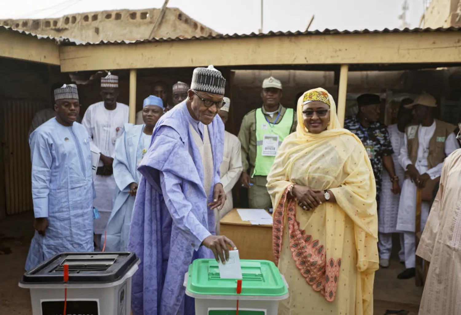 الرئيس النيجيري محمد بخاري يدلي بصوته برفقة زوجته عائشة في مسقط رأسه بمدينة دورا (أ.ب)