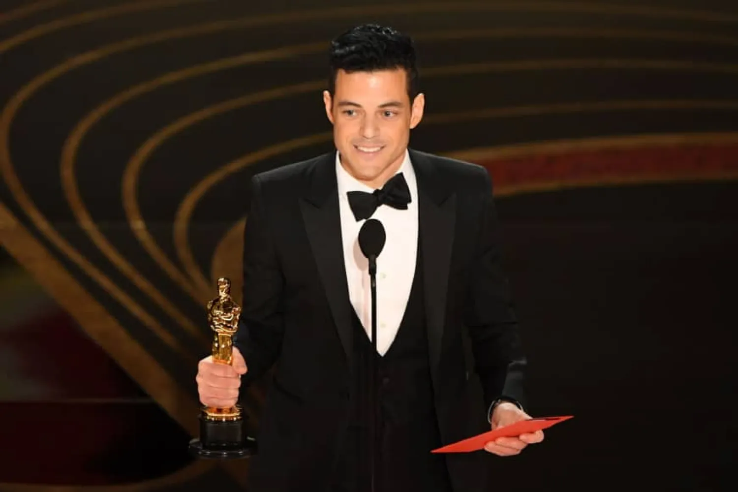 Rami Malek accepts the best actor Oscar for his portrayal of Freddie Mercury in "Bohemian Rhapsody" | AFP
