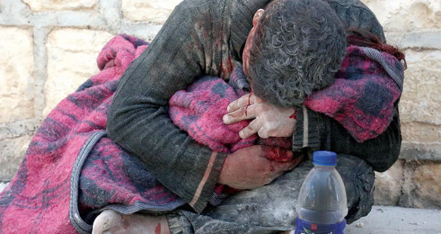 رجل يحتضن طفلته التي قتلت بقصف من قوات النظام على خان شيخون في ريف ادلب امس (أ.ف.ب)