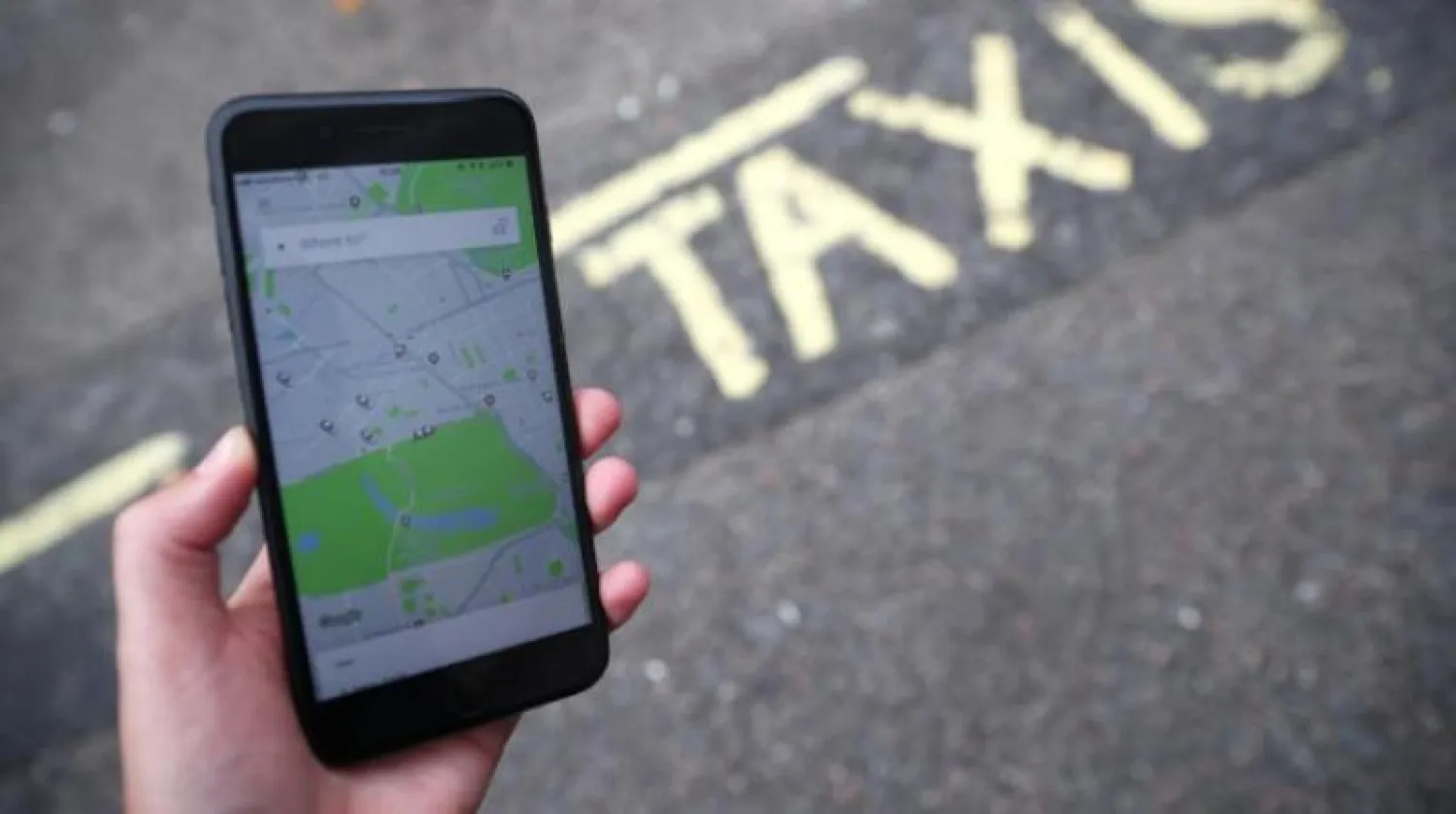 تطبيق «أوبر» على أحد الهواتف بشوارع لندن (رويترز)