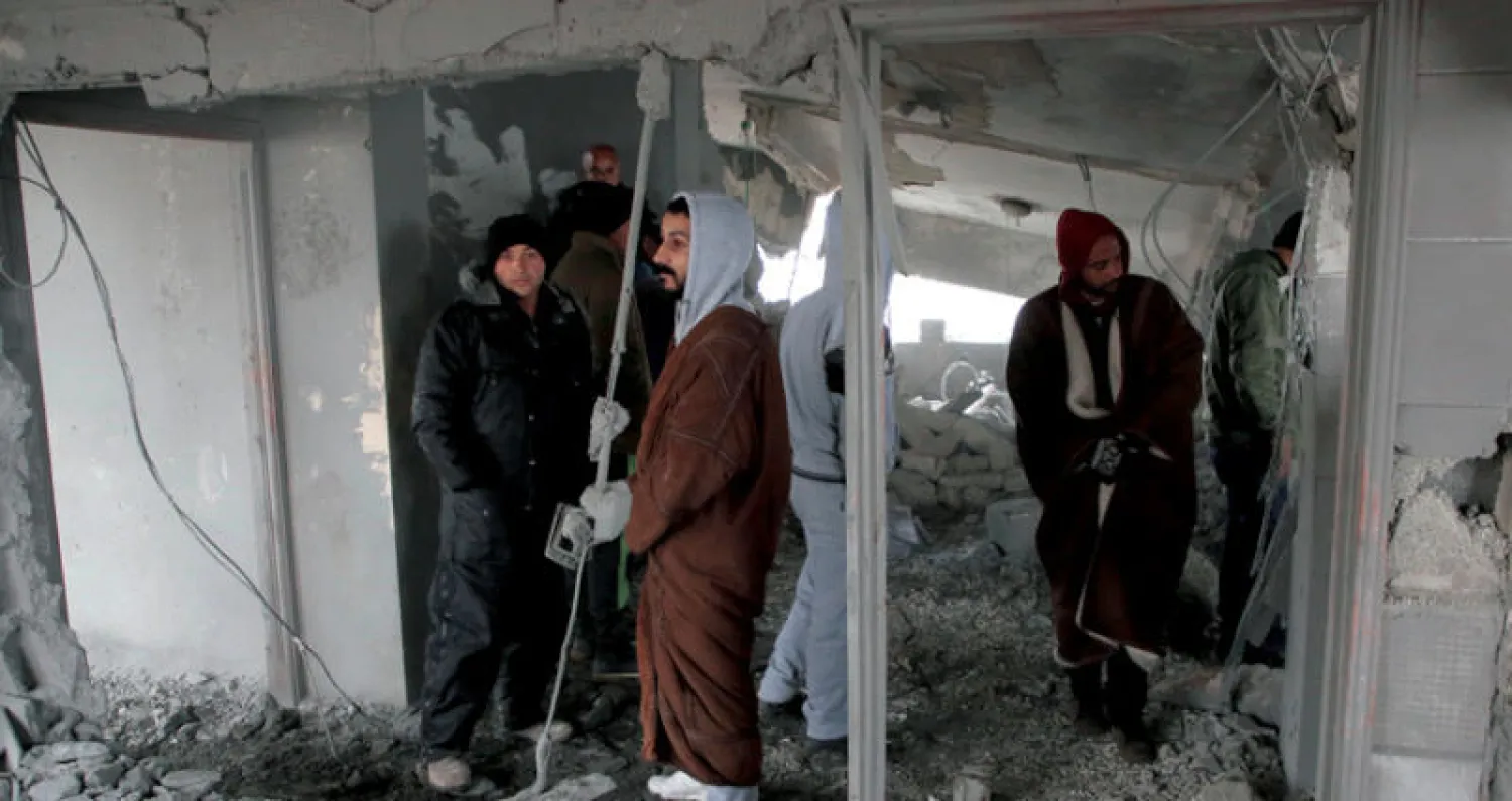 سكان في قرية يطا، جنوب الخليل، يتفقدون منزلاً هدمته السلطات الإسرائيلية مؤخراً (أ.ف.ب)