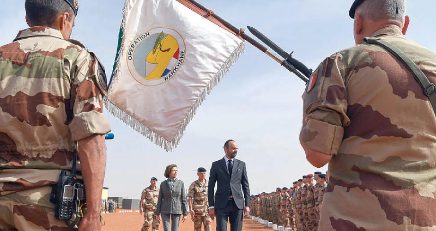 رئيس الوزراء الفرنسي إدوارد فيليب ووزيرة الدفاع فلورنس بارلي يستعرضان قوات بلدهما في قاعدة «براكين» العسكرية الفرنسية بمالي نهاية فبراير في جزء من زيارة استغرقت يومين (أ.ف.ب)