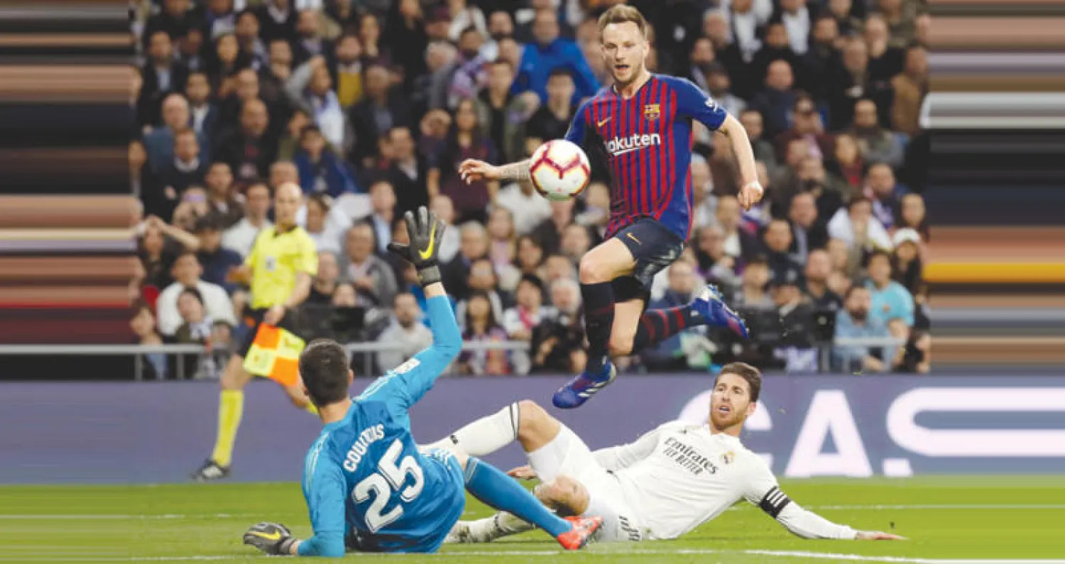 راكيتيتش يسدد من فوق كورتوا حارس ريال مدريد محرزاً هدف الانتصار لبرشلونة (إ.ب.أ)