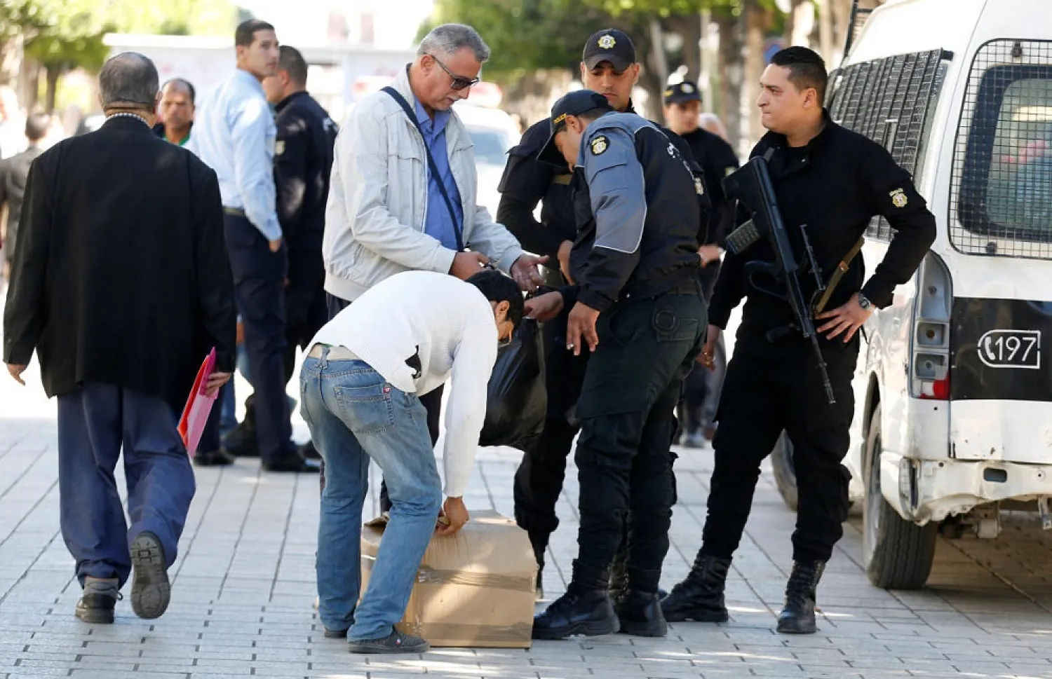 File picture shows policemen searching civilians belongings in Tunis, Tunisia. (Reuters)