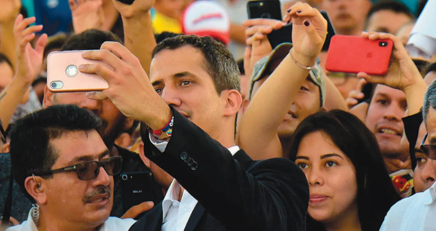 غوايدو يلتقط صورة سيلفي مع أنصاره في ساليناس بعد لقاء رئيس الإكوادور أول من أمس (أ.ف.ب)
