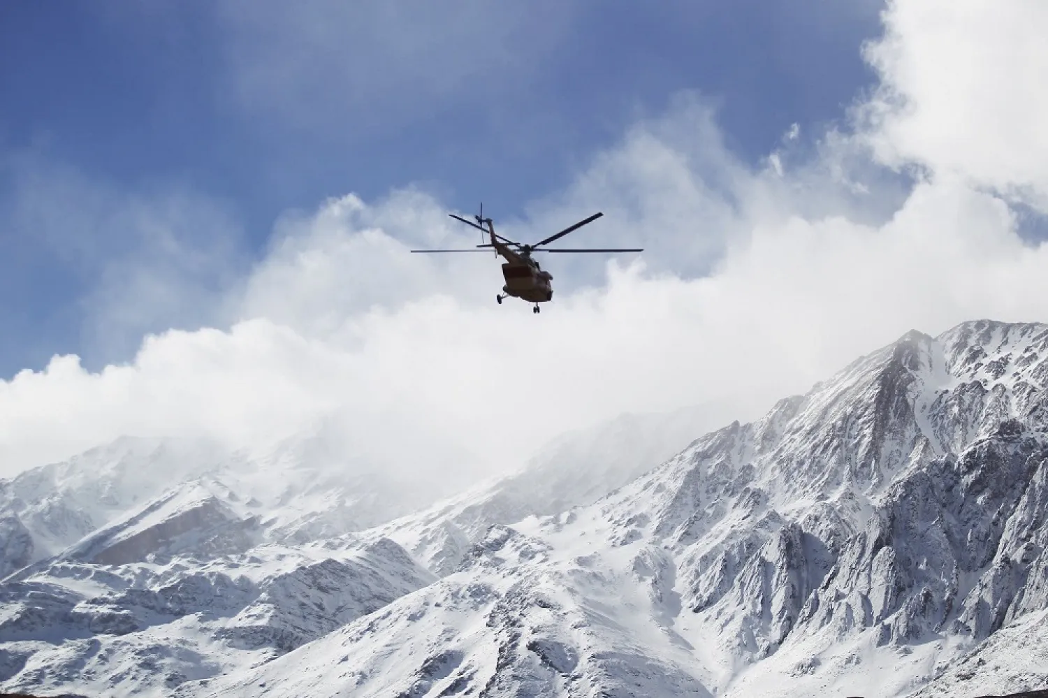 An emergency and rescue helicopter searches for a plane that crashed in a mountainous area of central Iran, February 19, 2018. (AP)