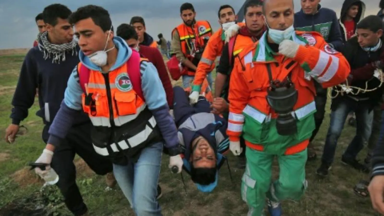 مسعفون فلسطينيون ينقلون مصاباً خلال مواجهات مع القوات الإسرائيلية على حدود قطاع غزة (أرشيف - أ.ف.ب)