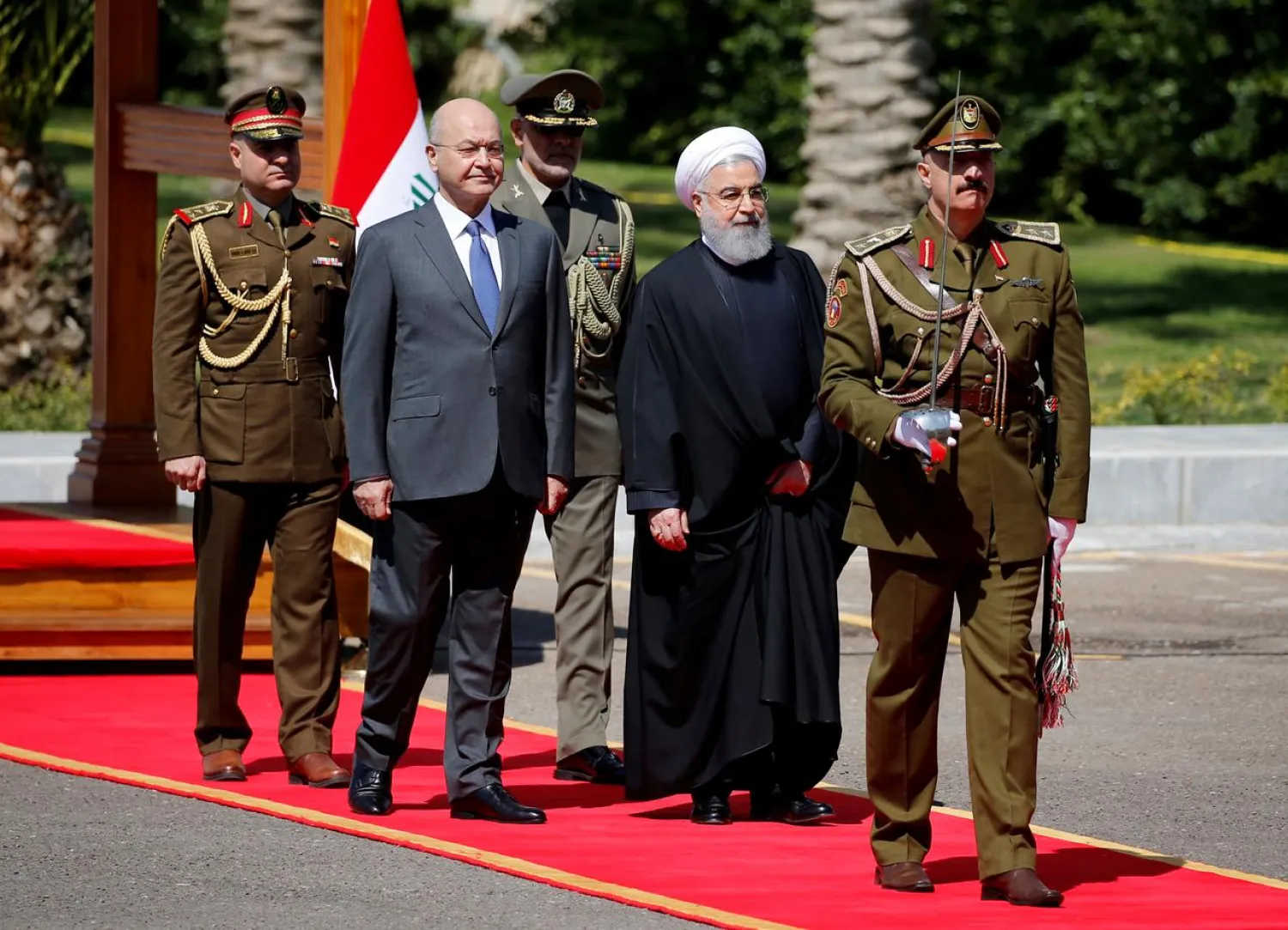 Iraq's President Barham Salih walks with Iranian President Hassan Rouhani during a welcome ceremony at Salam Palace in Baghdad, Iraq March 11, 2019. (Reuters)