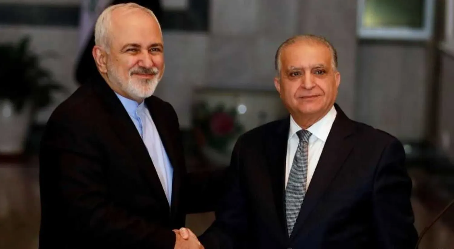 Iraqi Foreign Minister Mohammed Ali al-Hakim (right) meets Iranian counterpart Mohammed Javad Zarif in Baghdad (Reuters)