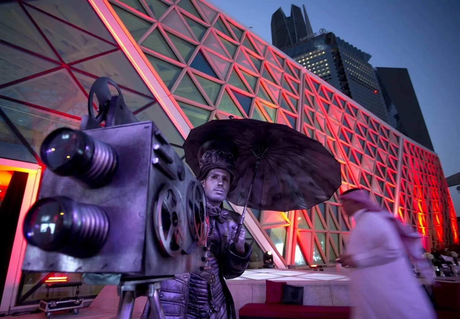 An actor poses with a replica of a vintage cinema camera as visitors enter a screening, at the King Abdullah Financial District Theater, in Riyadh, Saudi Arabia, in April 2018. (AP)