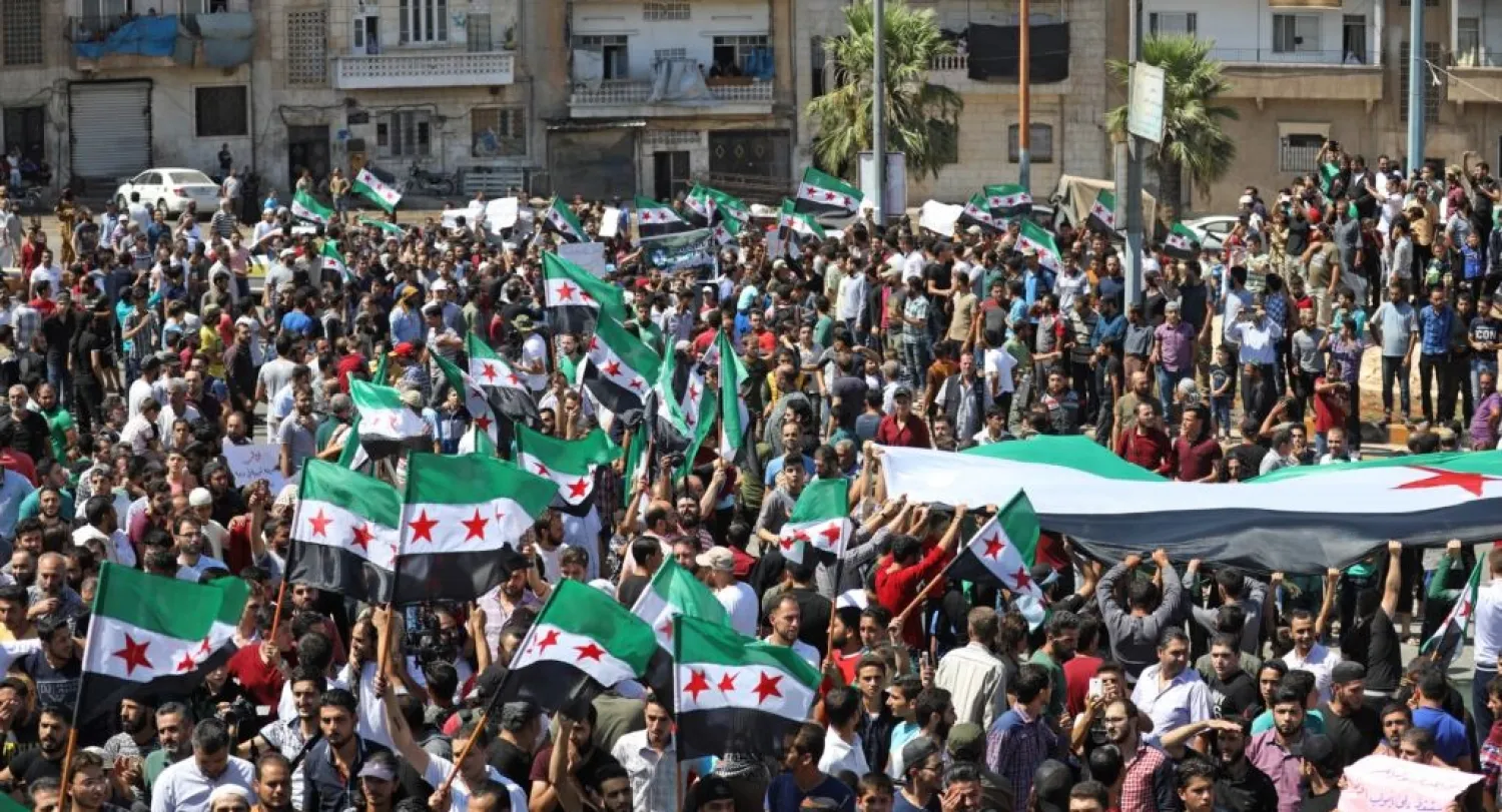 Syrian protesters wave their national flag as they demonstrate against the regime and its ally Russia in the opposition-held city of Idlib on September 7, 2018. (AFP)